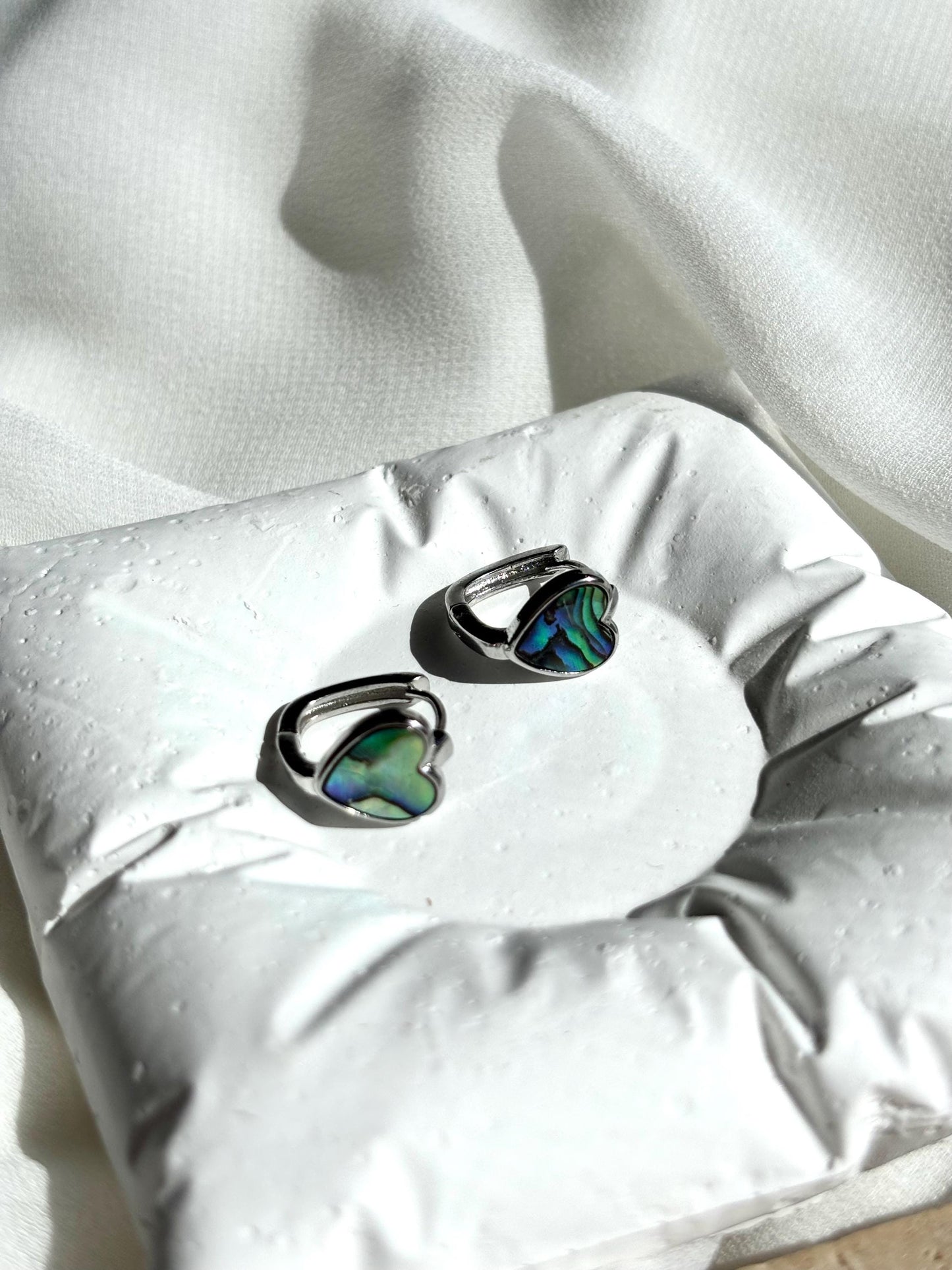 Heart-Shaped Mother of Pearl Huggie Earrings with Black and Blue Hues – Sterling Silver Wire